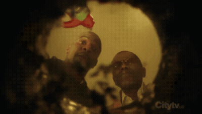 Two Men Looking Through Hole In Wall Saying Citytv GIF