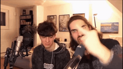 Two Men Making Funny Faces At Microphones GIF