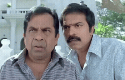 Two Men Making Funny Faces In Front Of Building GIF