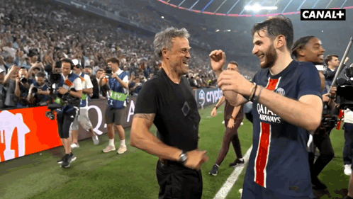 Two Men On A Soccer Field With Canal + In The Upper Right Corner GIF