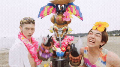 Two Men On Beach One Wearing Lei GIF