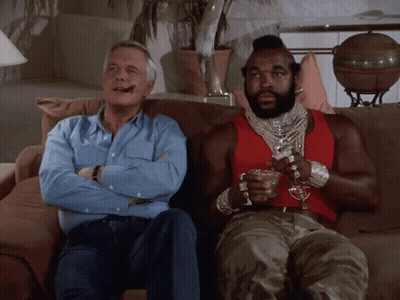 Two Men On Couch One In Red Tank Top GIF
