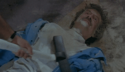 Two Men On Couch Talking, One Smoking Cigarette GIF