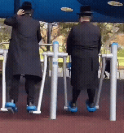 Two Men On Exercise Machines In Park GIF