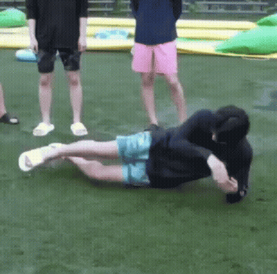 Two Men On Grass, One Lying One Standing GIF