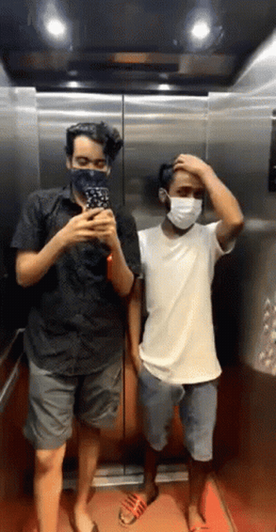 Two Men On Phones, One In Kona Shirt GIF