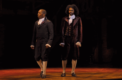 Two Men On Stage One In Suit GIF