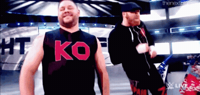 Two Men On Stage One Wearing Ko Shirt GIF