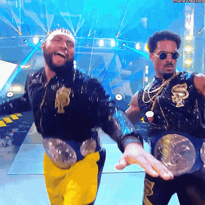 Two Men On Stage, One With Smackdown Belt GIF