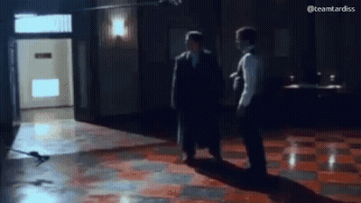 Two Men On Tiled Floor In Dark Room GIF