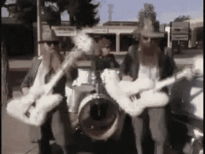Two Men Playing Guitars And Drums In Band GIF