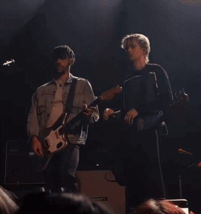 Two Men Playing Guitars On A Stage With A Hiwatt Amplifier In The Background GIF