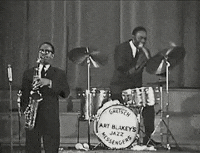 Two Men Playing Saxophone And Drums In Jazz Band GIF