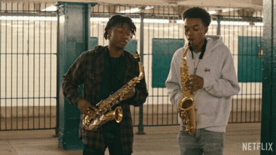 Two Men Playing Saxophones In A Netflix Video GIF