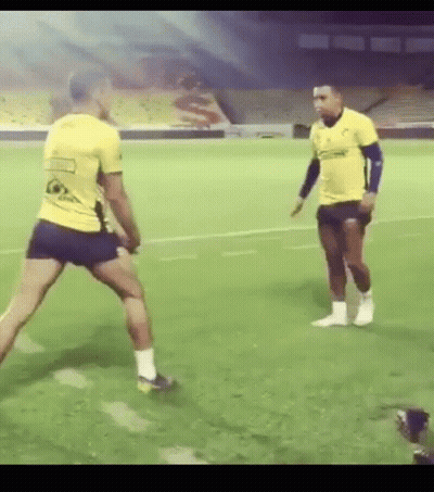 Two Men Playing Soccer In Front Of Stadium GIF