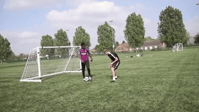 Two Men Playing Soccer One In Purple Shirt GIF