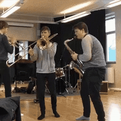 Two Men Playing Trombone And Saxophone GIF