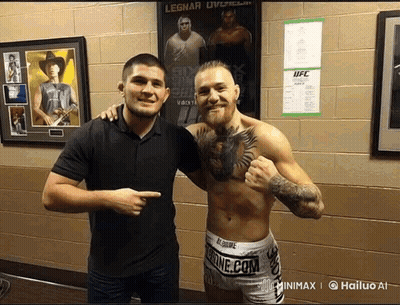 Two Men Posing In Front Of UFC Poster GIF