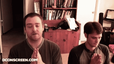 Two Men Praying In Front Of Bookshelf Dconscreen.com GIF