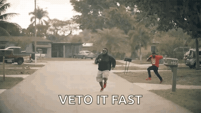 Two Men Running Down Street Saying Veto It Fast GIF