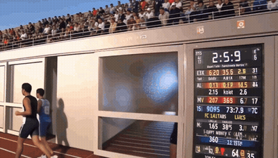 Two Men Running On Track With Scoreboard 2:5.9 GIF