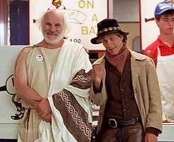Two Men Shake Hands In Front Of A Sign That Says " On A Bat " GIF