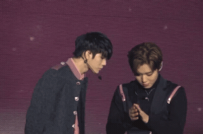 Two Men Shake Hands On A Stage With A Purple Background GIF