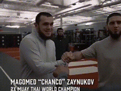 Two Men Shaking Hands In A Gym With The Words Magomed " Chanco " Zaynukov On The Bottom GIF
