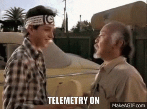 Two Men Shaking Hands In Front Of A Car With The Words Telemetry On Written Below Them . GIF