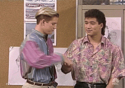 Two Men Shaking Hands In Front Of Bulletin Board GIF