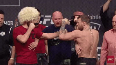 Two Men Shaking Hands In Front Of Crowd GIF