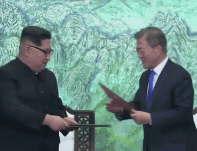 Two Men Shaking Hands in Front of Painting