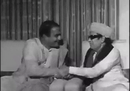 Two Men Shaking Hands On Couch GIF