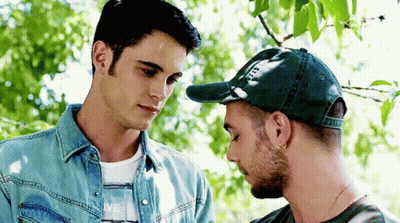 Two Men Side By Side, One In Green Hat GIF