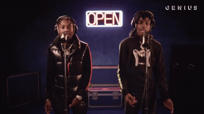 Two Men Sing In Front Of An Open Sign GIF