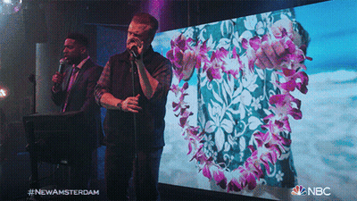 Two Men Singing In Front Of New Amsterdam Screen GIF