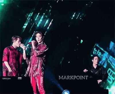 Two Men Singing Into Microphones On Stage GIF