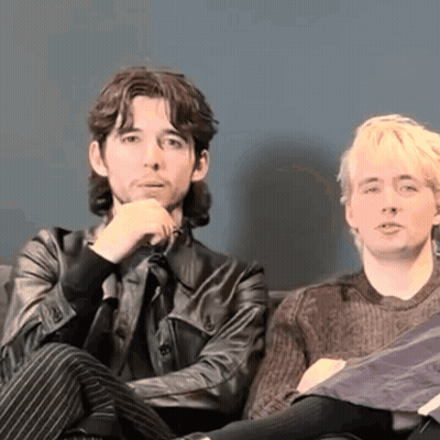 Two Men Sit On A Couch With Their Arms Crossed GIF