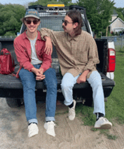 Two Men Sit On Back Of Truck GIF