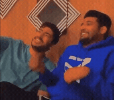 Two Men Sitting And Laughing One In Blue Hoodie GIF