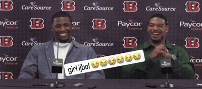 Two Men Sitting At A Table In Front Of A Backdrop That Says Caresource GIF