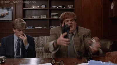 Two Men Sitting At A Table With One Saying Oh My God We 'Re Burning Alive While The Other Holds A Gun GIF
