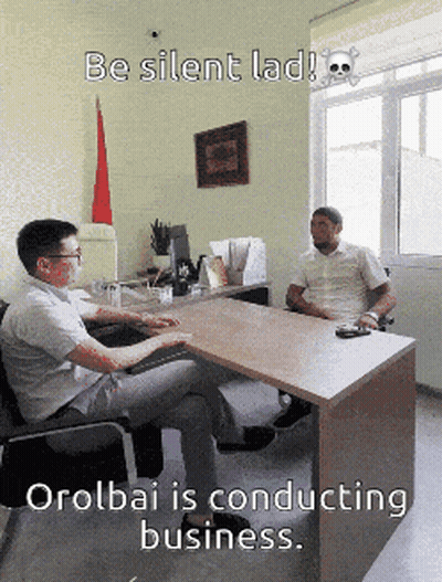 Two Men Sitting At Desk With Skull And Crossbones GIF