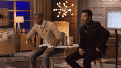 Two Men Sitting At Microphone With TCP Sign GIF