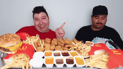 Two Men Sitting At Table Full Of McDonald's Food GIF