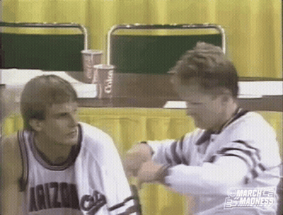 Two Men Sitting At Table One In Arizona Shirt GIF