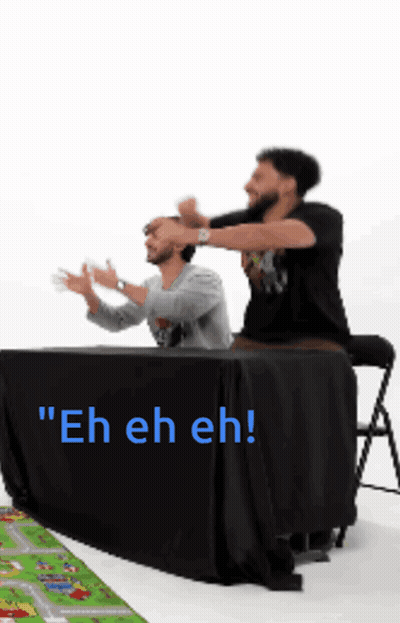 Two Men Sitting at Table Saying Eh Eh Eh