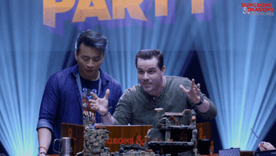 Two Men Sitting At Table With Dungeons & Dragons Sign GIF