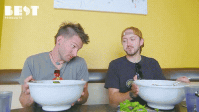 Two Men Sitting At Table With Food GIF