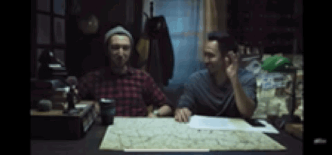 Two Men Sitting At Table With Map Talking GIF